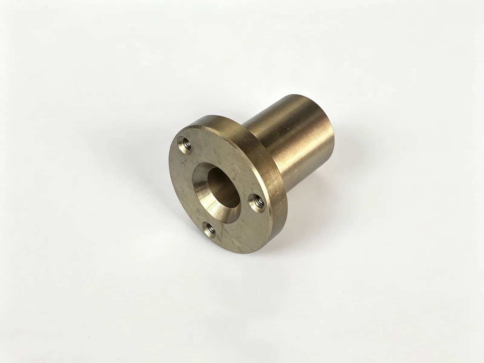 CNC-machined brass flanged sleeve with a through-bore and threaded mounting holes
