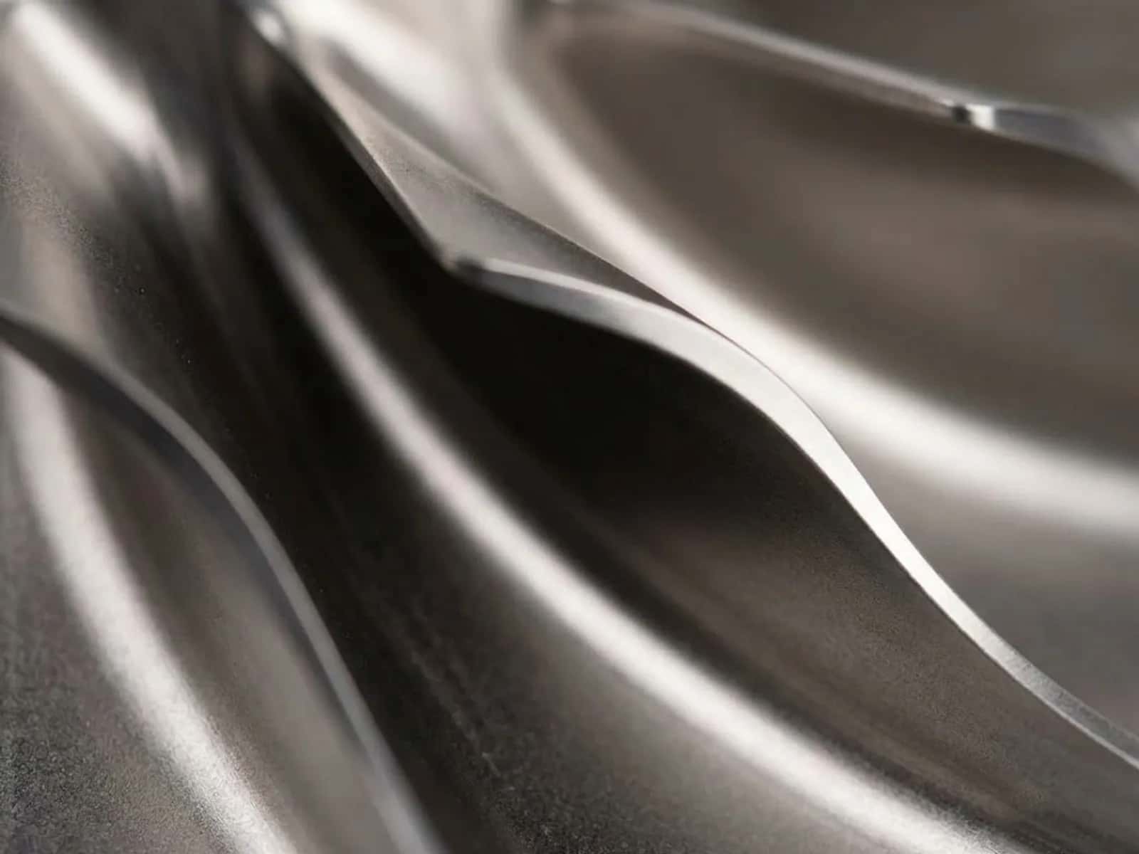 Close-up of five-axis machined metal impeller blades with chatter-free curved surfaces
