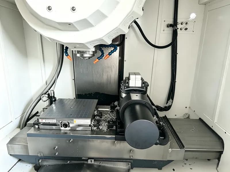 Five-axis CNC machine worktable and spindle inside an enclosed machining center